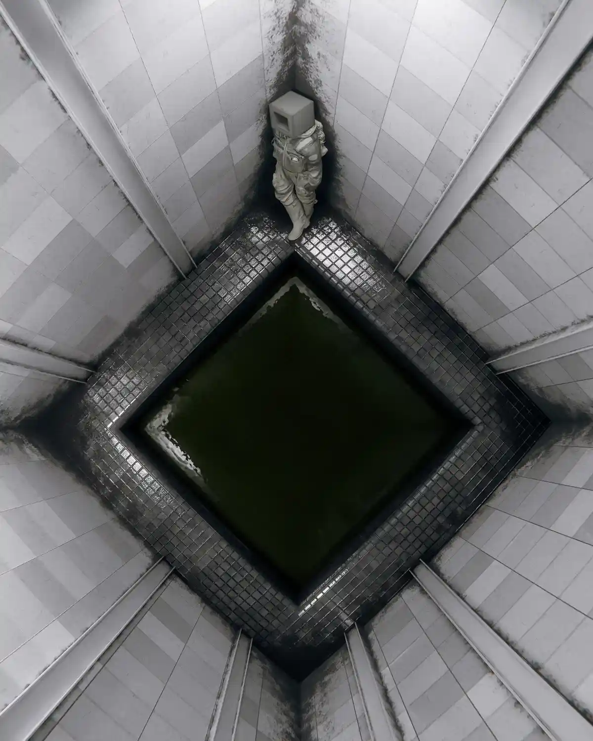 An astronaut in a white suit stands in the corner of a tiled, grimy, geometrically distorted room, next to a square pool of…