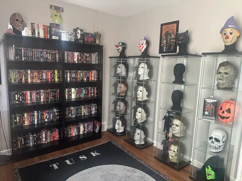 A room filled with horror movie memorabilia, including numerous Michael Myers masks displayed in glass cases, a large…