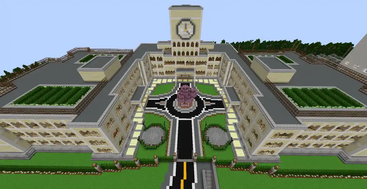 A Minecraft-style digital rendering of a large, symmetrical school building with a central courtyard, clock tower, and…