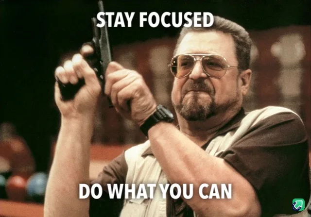 A man with a beard and aviator sunglasses holds a handgun with both hands, aiming forward with a serious expression. The…