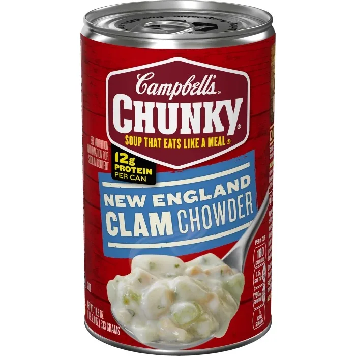 A red can of Campbell's Chunky New England Clam Chowder soup, featuring a spoonful of creamy chowder with visible clams and…