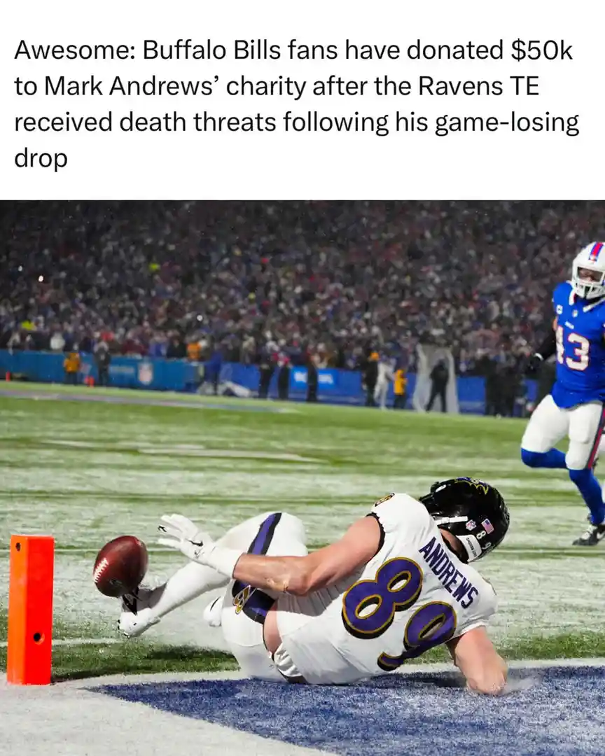 A Baltimore Ravens tight end, Mark Andrews (jersey #80), is shown falling backward on a snowy football field after dropping…