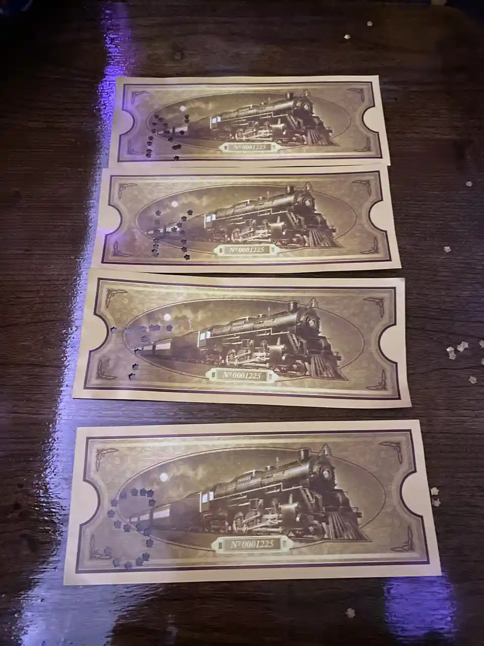 Four identical vintage-style train ticket stubs, each featuring a sepia-toned illustration of a steam locomotive, are…