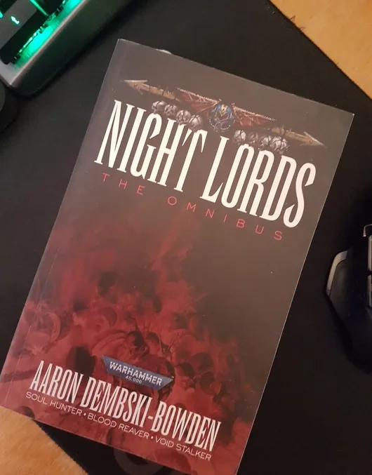A close-up photo of the 'Night Lords: The Omnibus' book by Aaron Dembski-Bowden, part of the Warhammer 40,000 universe…
