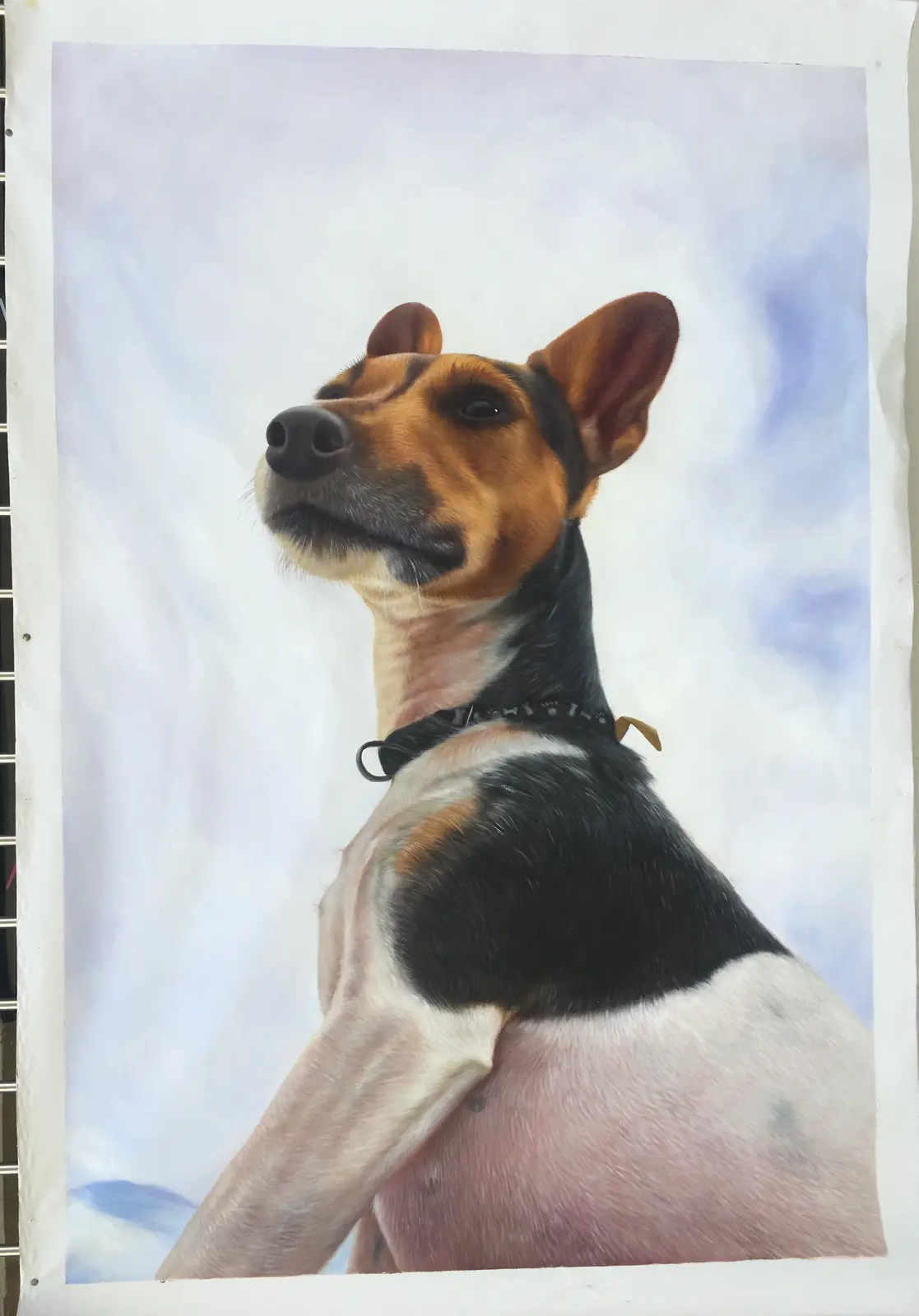 A realistic painting of a dog with a black, white, and tan coat, wearing a collar, looking upward against a cloudy sky…