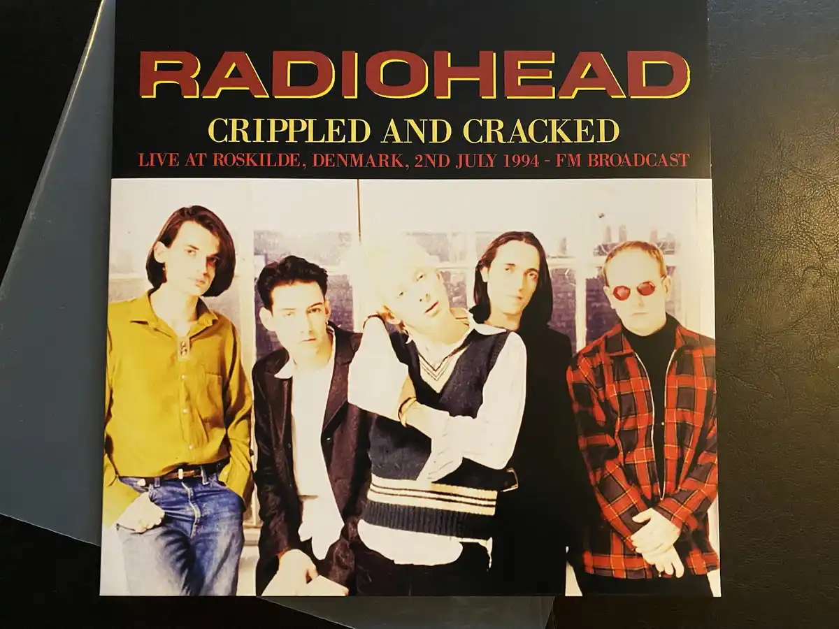 The image shows the album cover for Radiohead's 'Crippled and Cracked,' featuring a photo of the five band members from…