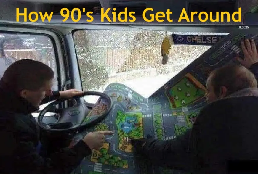 Two people are inside a vehicle, one driving and the other pointing at a large, colorful plastic toy map spread across the…