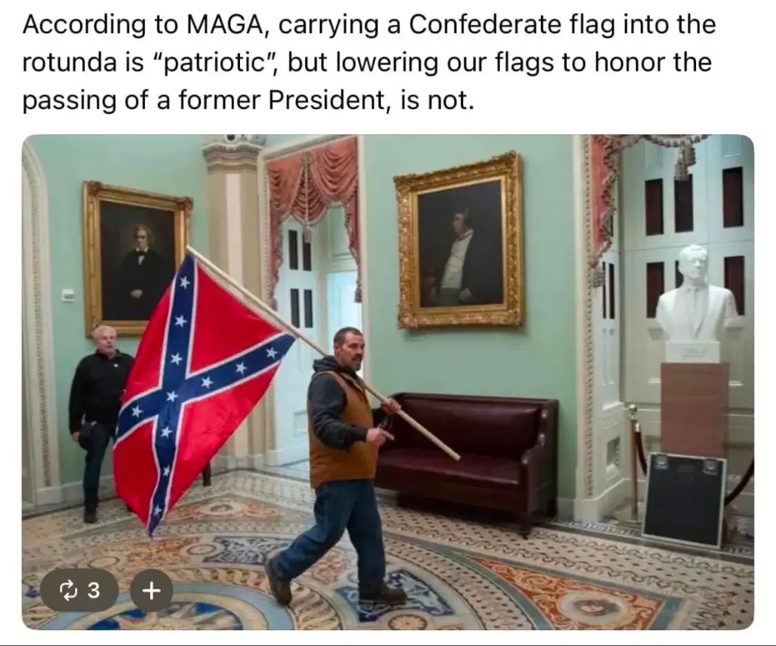 A man walks through an ornate, formal interior space, possibly a government building rotunda, carrying a Confederate battle…
