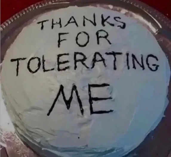 A close-up of a round cake with light blue frosting, sitting on a silver platter. The cake has the words 'THANKS FOR…