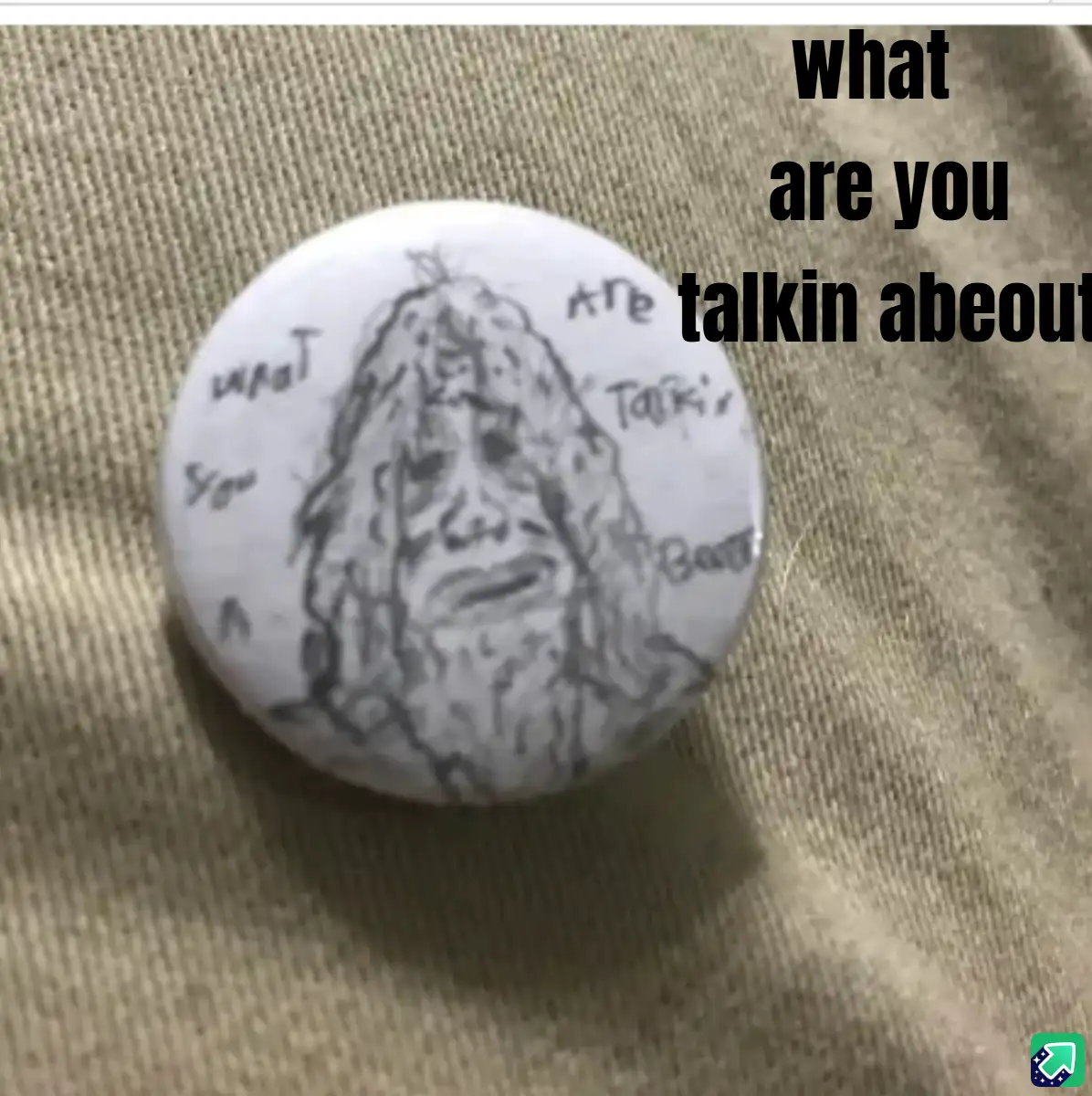 A close-up photo of a round, white button with a hand-drawn sketch of a man with long hair and a beard, surrounded by the…