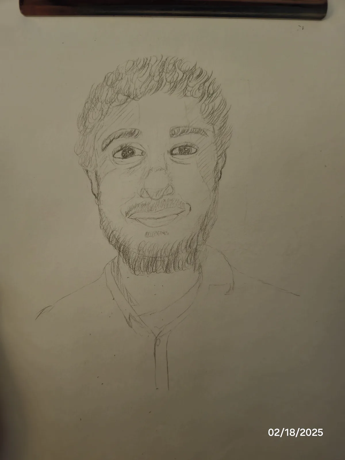A pencil sketch of a man with curly hair, a beard, and a collared shirt, drawn on paper and mounted on a wall. The date…