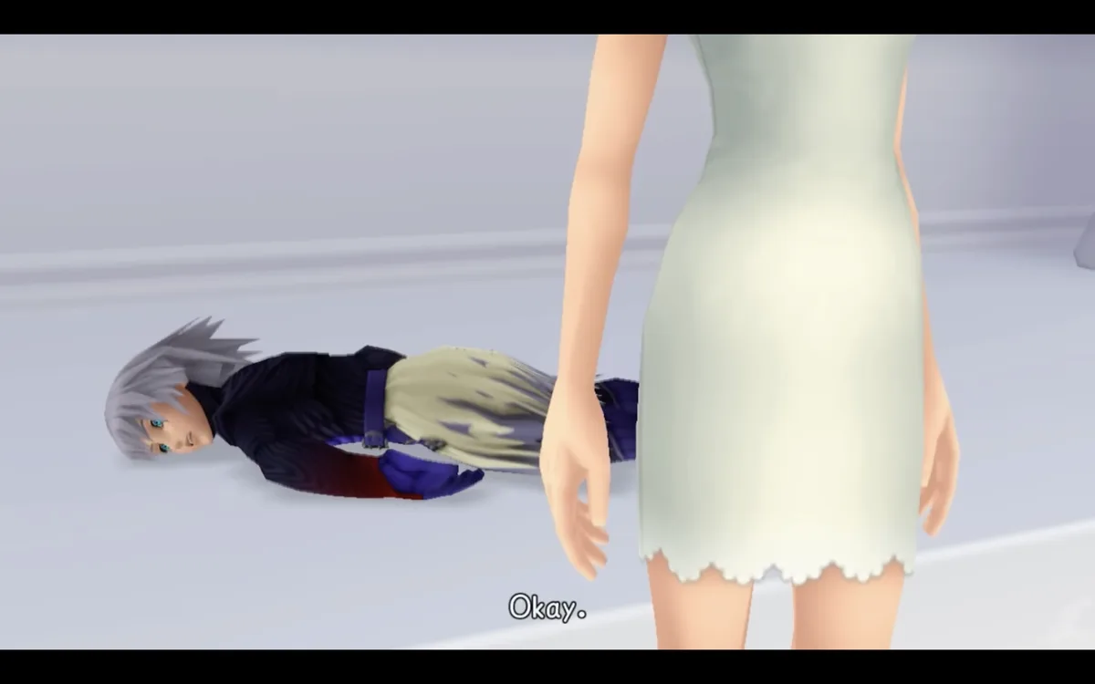 A screenshot from a video game shows a male anime-style character with silver hair lying motionless on a plain white floor…