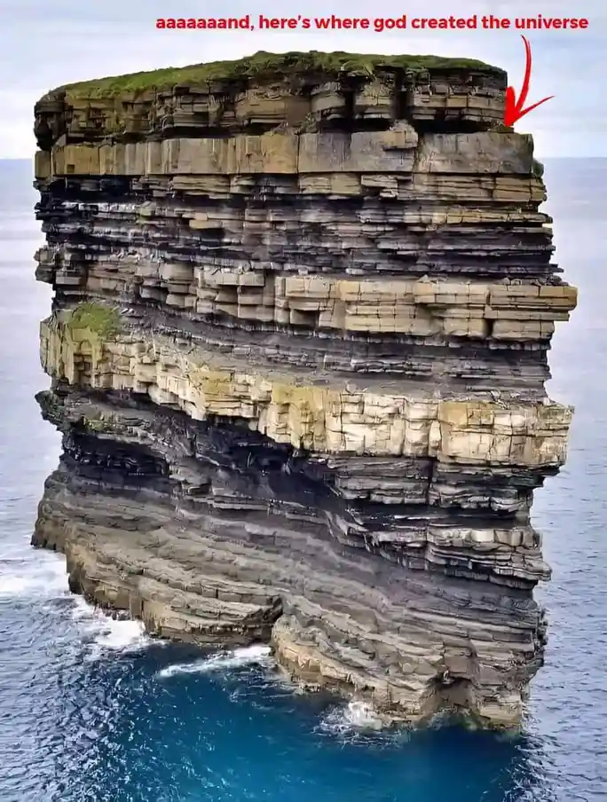 A tall, layered sea stack rises from the ocean, its top covered in green moss. Red text at the top reads 'aaaaaaand, here's…