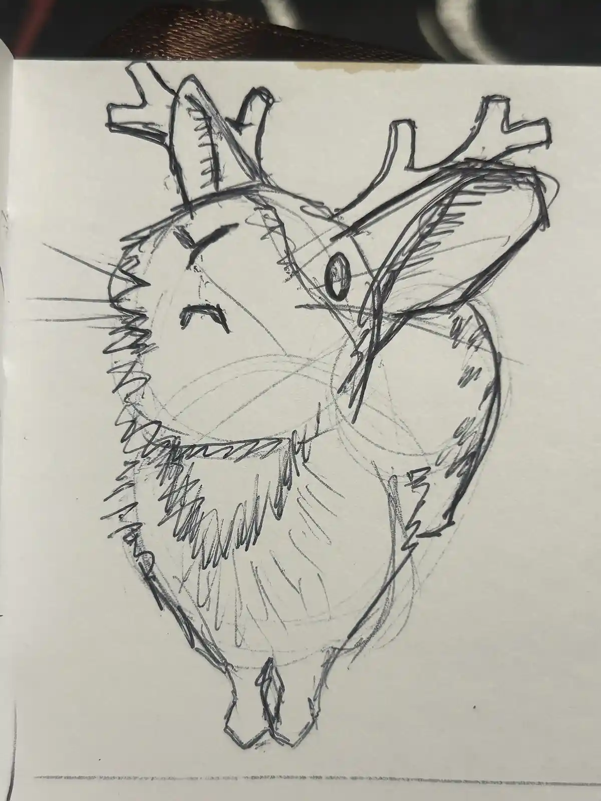 A rough pencil sketch on paper depicts a stylized deer with antlers, but the overall shape of the drawing is clearly a…