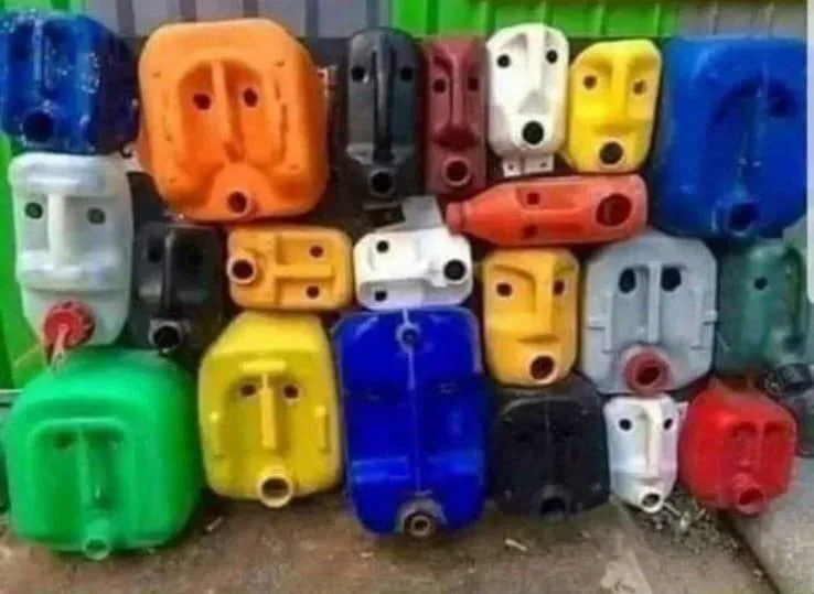A wall of colorful plastic jerry cans arranged in a grid, each one has holes and spouts that resemble human facial features…