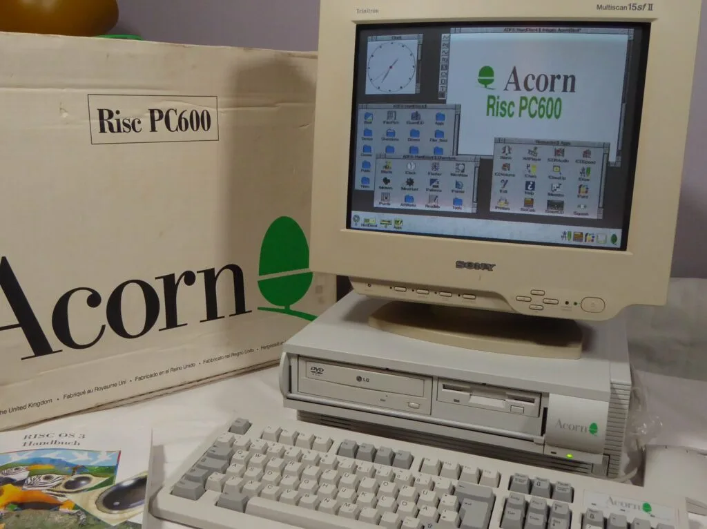 An Acorn Risc PC600 computer setup with a beige Sony monitor displaying the Acorn Risc PC600 desktop, sitting on top of the…