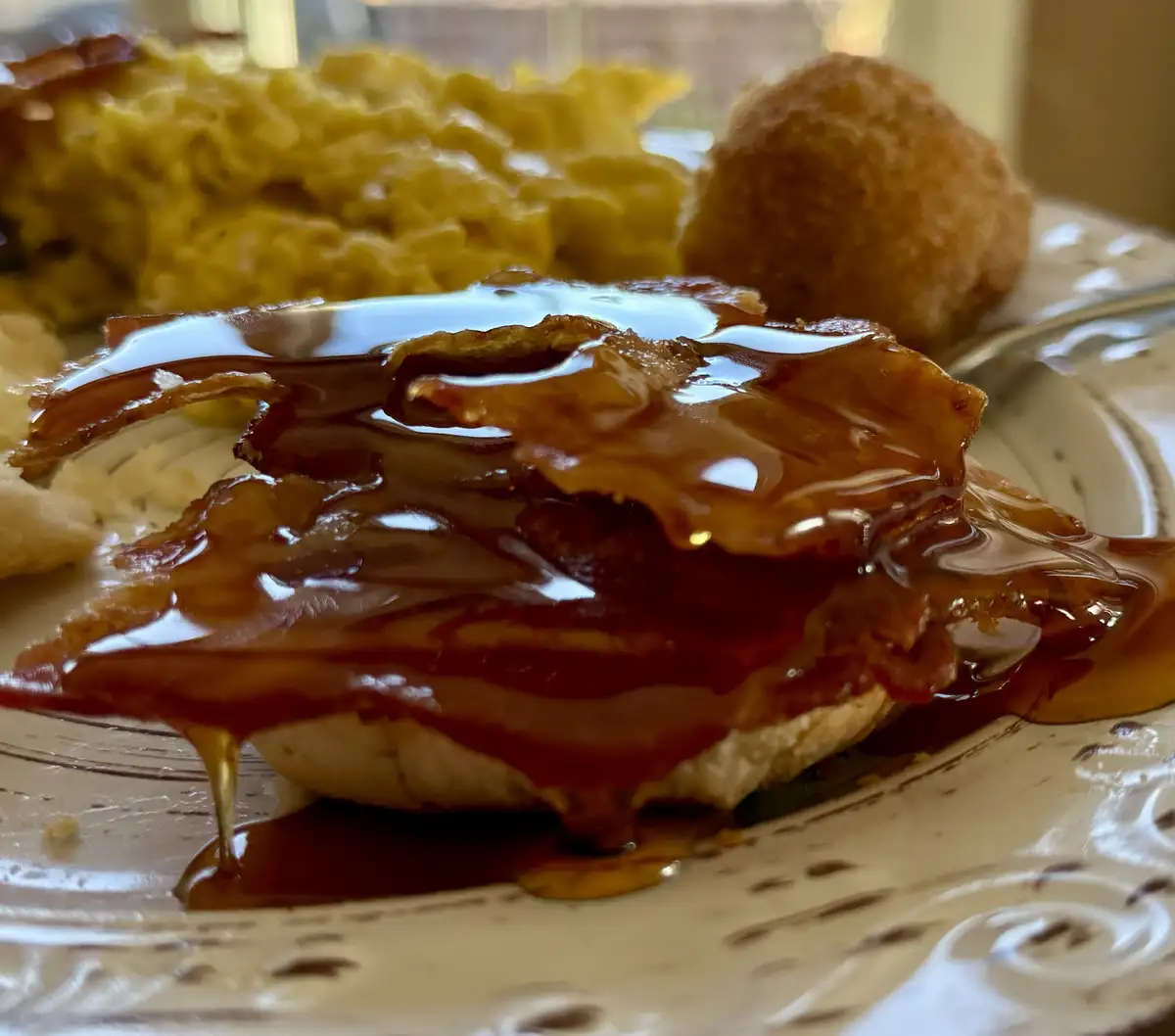 Indulging in hot honey on a crispy bacon biscuit!