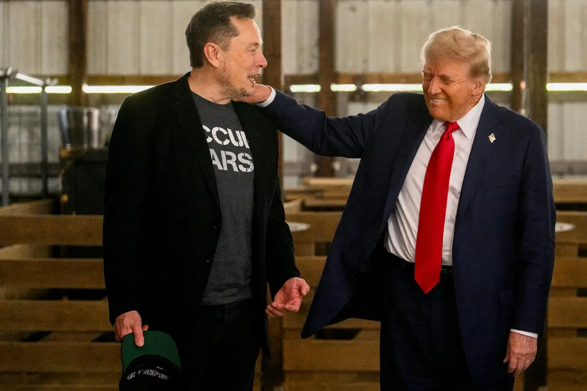 elon musk wears a gray t-shirt with the partially visible text 'OCCUPY MARS' while standing next to donald trump, who has…