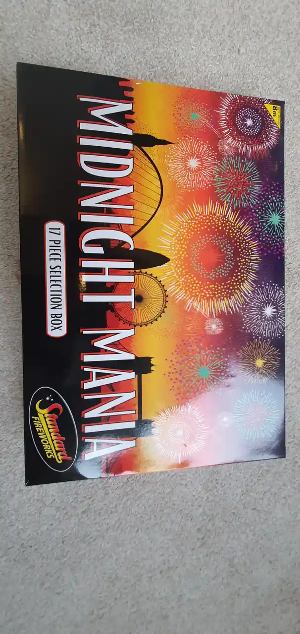 A box of 'Midnight Mania' fireworks by Standard Fireworks, featuring a vibrant illustration of London landmarks like the…