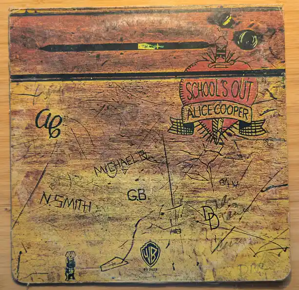 A heavily scratched and worn record album cover for Alice Cooper's 'School's Out', covered in numerous handwritten…