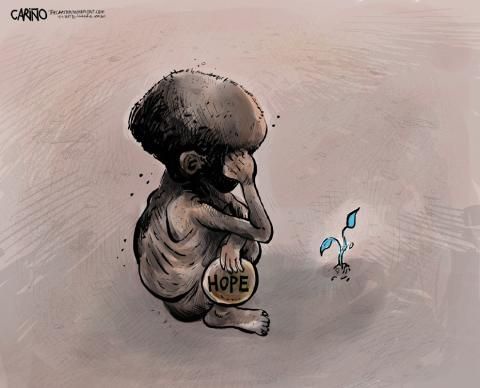 A small, emaciated child sits hunched over, covering its face with one hand, holding a stone inscribed with the word 'HOPE'…