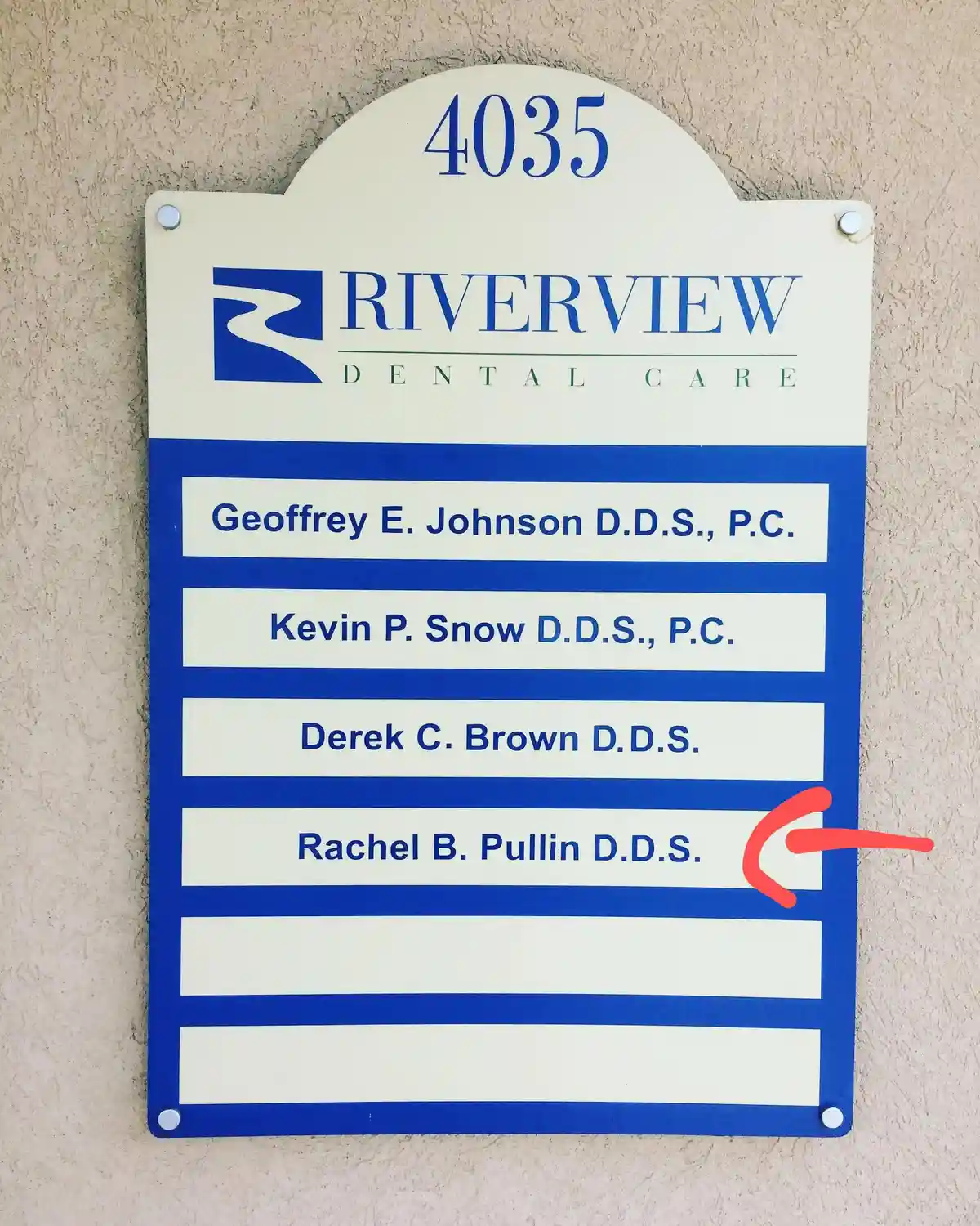 A dental office sign for Riverview Dental Care at address 4035 lists four dentists, with a red arrow pointing to the name…