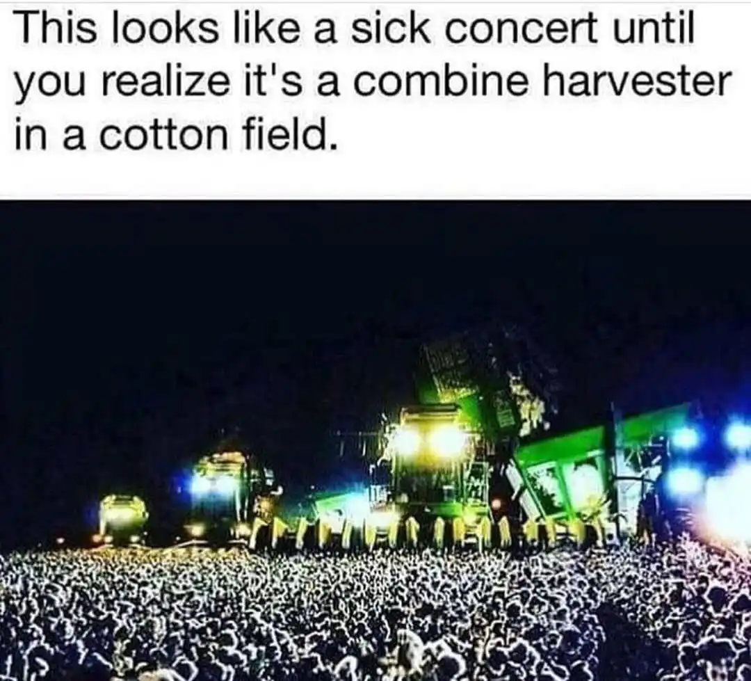 The image shows several large, brightly lit combine harvesters in a field at night, with a massive crowd of people below…