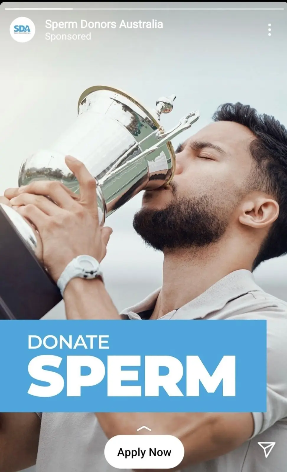 A man with a beard is kissing a large silver trophy, overlaid with a blue banner that says 'DONATE SPERM' and a button that…